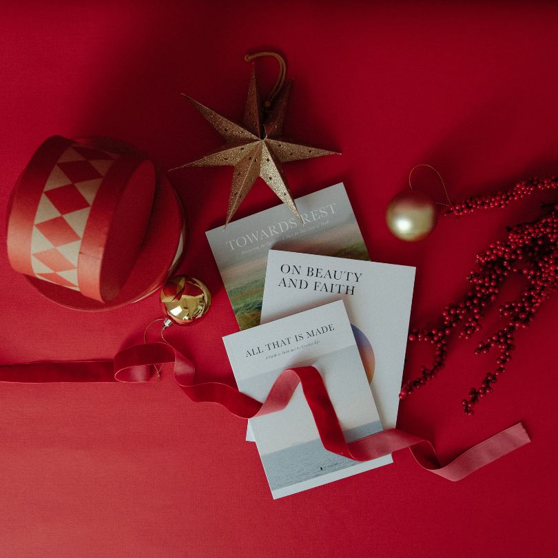 Three Alabaster content books surrounded by Christmas decor